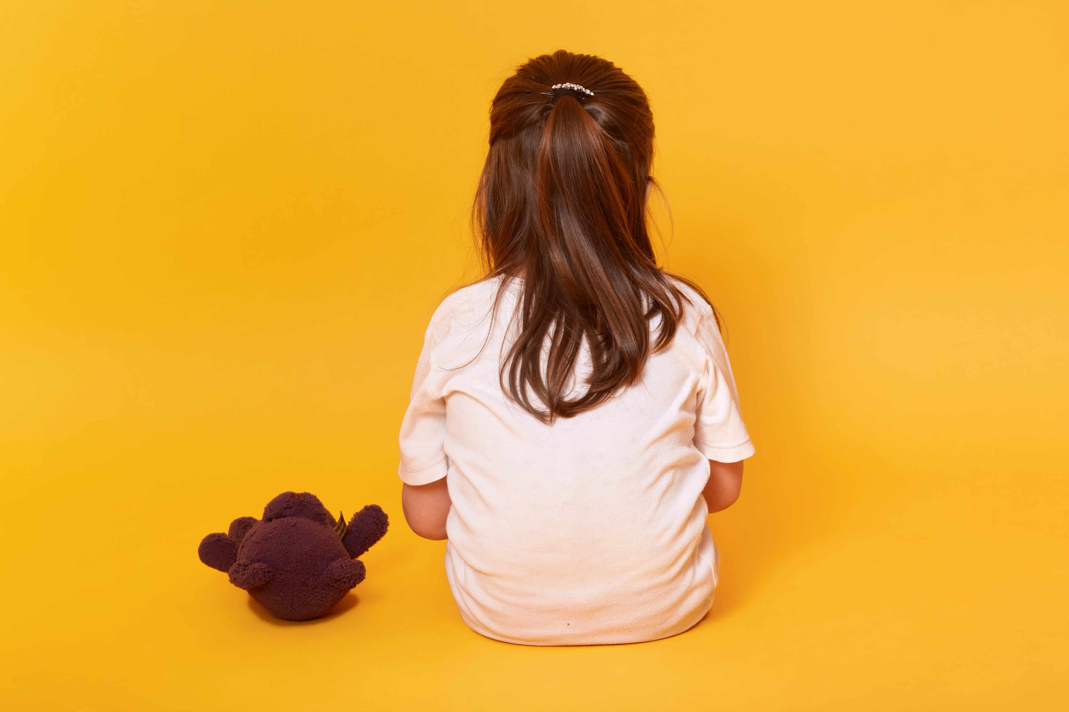 Girl sitting alone, representing the isolation of exclusion and bullying